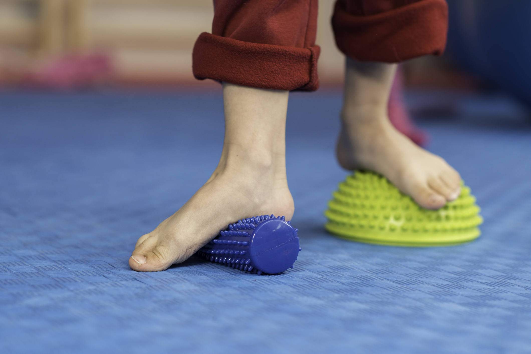 Flat feet physical therapy - Little boy stepping onto spiked rubber roller